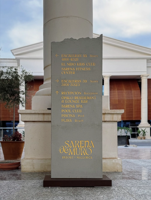 Directorio de servicios en tótem con textura efecto piedra, sistema de wayfinding y orientación para complejos hoteleros.
